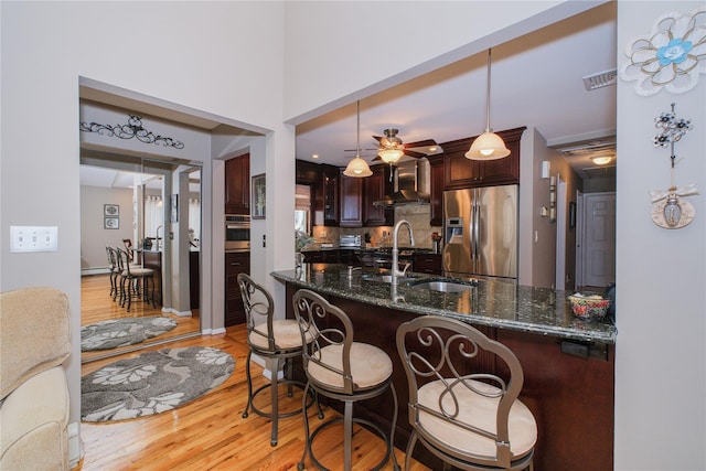 63 Dorval Ave, Staten Island, NY 10312 - kitchen with appliances with stainless steel finishes, a sink, wall chimney range hood, and light wood-type flooring