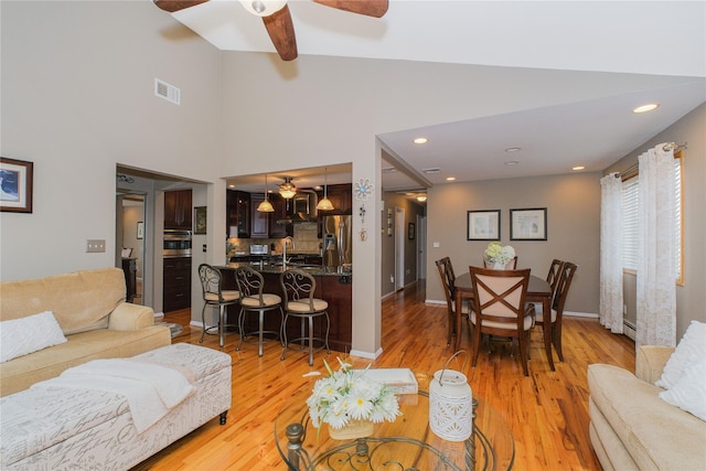63 Dorval Ave, Staten Island, NY 10312 - living room featuring ceiling fan, light wood-type flooring, recessed lighting, a high ceiling, and a baseboard heating unit