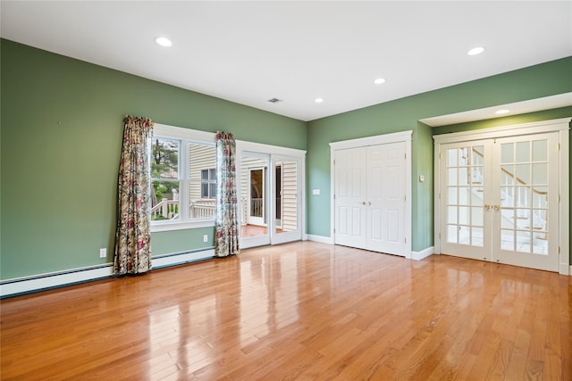 10 Stewart St, East Islip, NY 11730 - empty room with french doors, baseboard heating, wood finished floors, recessed lighting, and baseboards