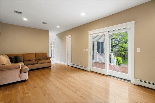 10 Stewart St, East Islip, NY 11730 - living area with a baseboard radiator, light wood-style floors, recessed lighting, and baseboards