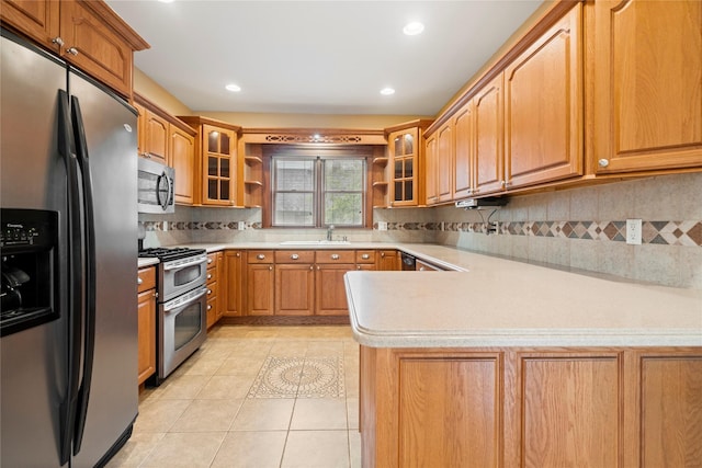 10 Stewart St, East Islip, NY 11730 - kitchen with stainless steel appliances, a peninsula, light countertops, glass insert cabinets, and recessed lighting