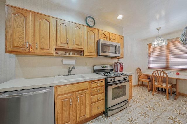 60-51 71st St, Maspeth, NY 11378 - kitchen featuring stainless steel appliances, a sink, light countertops, light floors, and hanging light fixtures