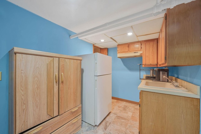60-51 71st St, Maspeth, NY 11378 - kitchen with freestanding refrigerator, a sink, under cabinet range hood, light countertops, and baseboards
