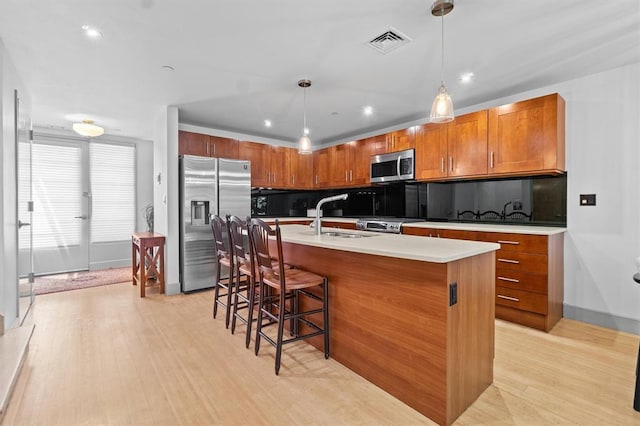 45 Main St Unit 3K, Hastings-On-Hudson, NY 10706 - kitchen featuring stainless steel appliances, light wood-style flooring, a sink, a kitchen bar, and recessed lighting