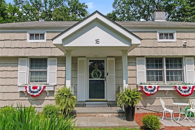 16 Lyncrest Rd, Cortlandt Manor, NY 10567 - view of exterior entry featuring a chimney and a porch