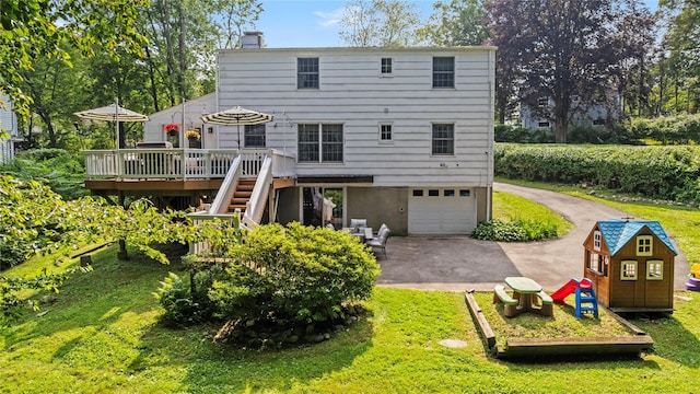 16 Lyncrest Rd, Cortlandt Manor, NY 10567 - back of house with driveway, a wooden deck, a chimney, a garage, and stairway