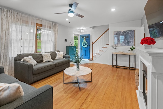 16 Lyncrest Rd, Cortlandt Manor, NY 10567 - living room with stairway, a fireplace with raised hearth, wood finished floors, ceiling fan, and recessed lighting