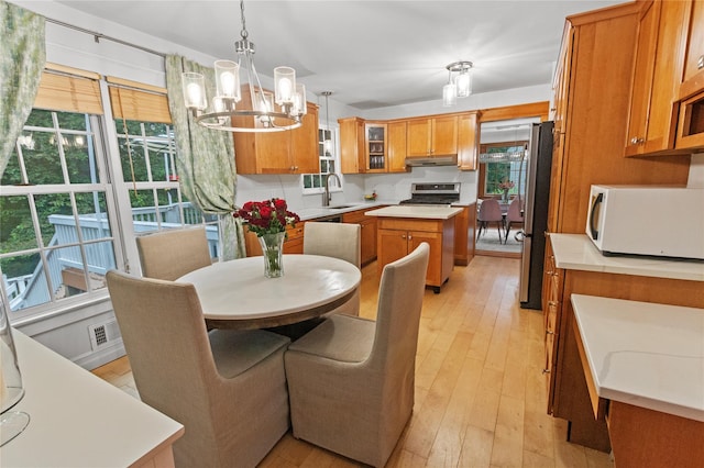16 Lyncrest Rd, Cortlandt Manor, NY 10567 - kitchen featuring white microwave, brown cabinetry, a chandelier, range, and light wood finished floors
