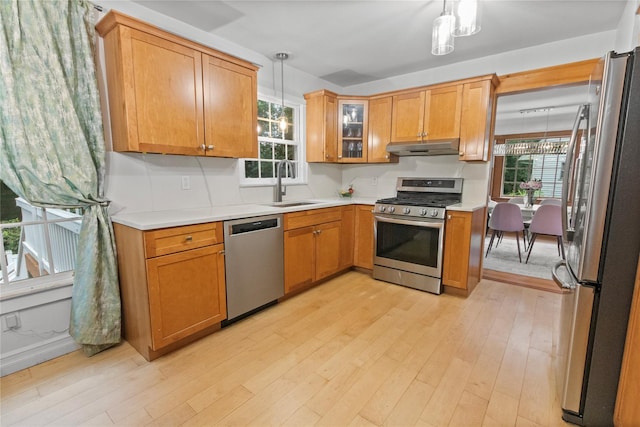 16 Lyncrest Rd, Cortlandt Manor, NY 10567 - kitchen with stainless steel appliances, under cabinet range hood, light wood-style flooring, light countertops, and hanging light fixtures