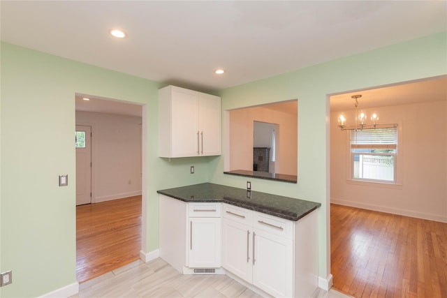 129 S St, Warwick, NY 10990 - kitchen with white cabinetry, light wood finished floors, a chandelier, baseboards, and recessed lighting