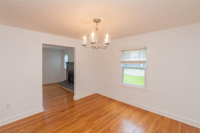 129 S St, Warwick, NY 10990 - empty room with a chandelier, light wood-type flooring, baseboards, and a fireplace