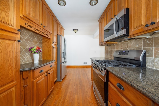 924 Violet Ave, Hyde Park, NY 12538 - kitchen with stainless steel appliances, baseboards, brown cabinets, and light wood-style floors
