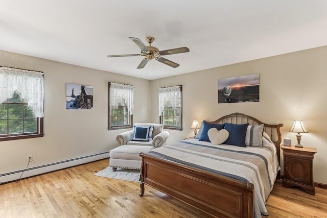 6295 N Country Rd, Wading River, NY 11792 - bedroom featuring wood finished floors, a baseboard heating unit, and ceiling fan