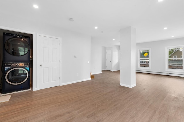 8 Chestnut St, Middletown, NY 10940 - unfurnished living room with stacked washing machine and dryer, a baseboard heating unit, wood finished floors, recessed lighting, and baseboards