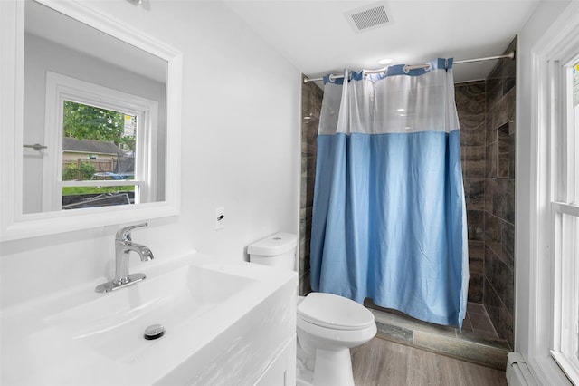 8 Chestnut St, Middletown, NY 10940 - full bath with toilet, vanity, a tile shower, baseboard heating, and wood finished floors