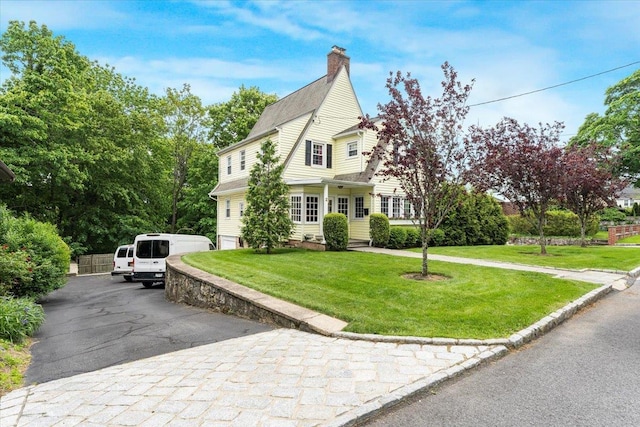 21 Chester Pl, New Rochelle, NY 10801 - view of front of house with a front yard, a chimney, and asphalt driveway