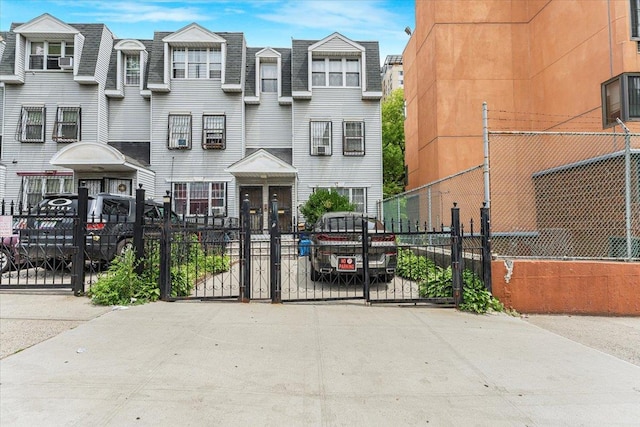 977 E 179th St, Bronx, NY 10460 - view of front of house with a gate, mansard roof, and roof with shingles