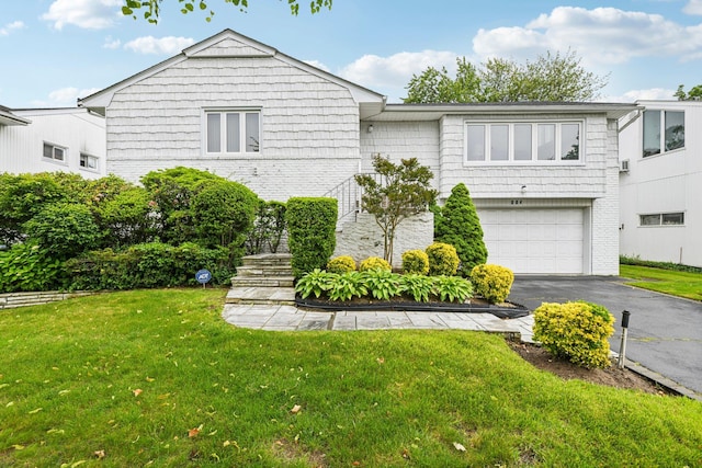 904 Woodmere Dr, North Woodmere, NY 11581 - view of front of home featuring a garage, driveway, a front yard, and brick siding
