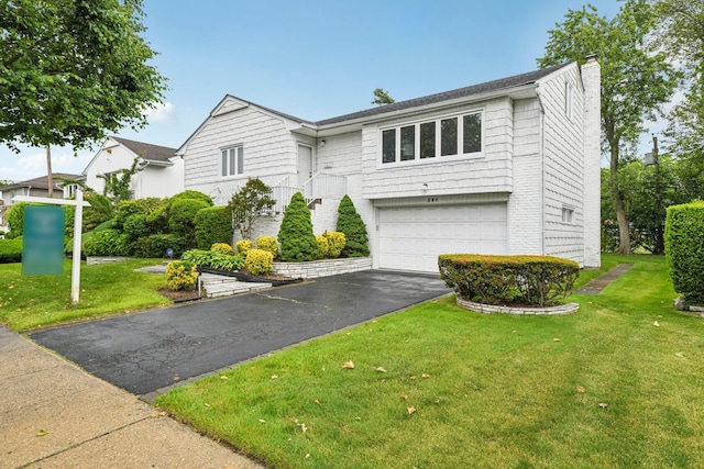 904 Woodmere Dr, North Woodmere, NY 11581 - view of front of house featuring a chimney, a garage, driveway, and a front yard