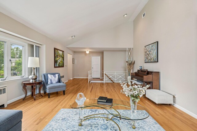 904 Woodmere Dr, North Woodmere, NY 11581 - living area with wood finished floors, radiator, baseboards, and vaulted ceiling