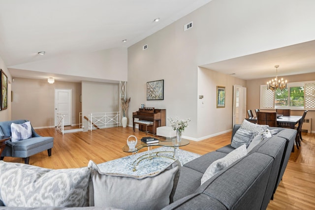 904 Woodmere Dr, North Woodmere, NY 11581 - living area with a chandelier, wood finished floors, baseboards, and high vaulted ceiling