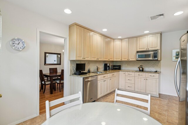 904 Woodmere Dr, North Woodmere, NY 11581 - kitchen featuring stainless steel appliances, decorative backsplash, a sink, light stone counters, and recessed lighting