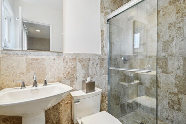 904 Woodmere Dr, North Woodmere, NY 11581 - bathroom featuring toilet, a sink, a stall shower, and tile walls