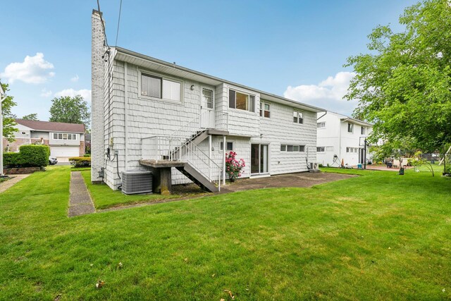 904 Woodmere Dr, North Woodmere, NY 11581 - rear view of house featuring central AC, a chimney, a lawn, and stairway