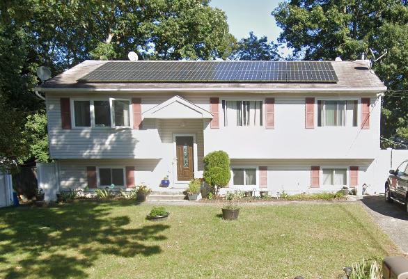 165 N 27th St, Wyandanch, NY 11798 - raised ranch featuring solar panels and a front lawn
