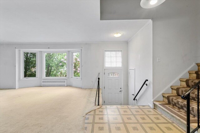 18 Overlook Ln, Plainview, NY 11803 - carpeted entryway featuring radiator, healthy amount of natural light, stairway, and ornamental molding