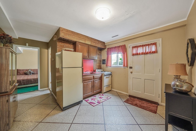 47-04 167th St, Flushing, NY 11358 - kitchen with white appliances, light flooring, brown cabinetry, baseboards, and a sink