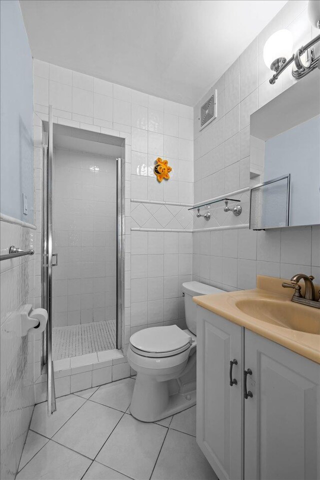 750 Kappock St Unit 1A, Bronx, NY 10463 - full bath with tile walls, vanity, a shower stall, toilet, and tile patterned flooring