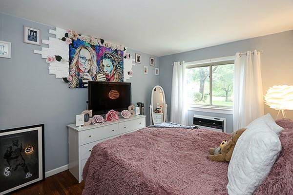 2449 Union Blvd Unit 24A, Islip, NY 11751 - bedroom with dark wood-style flooring, baseboards, and an AC wall unit