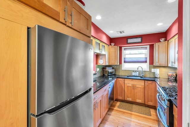 1425 Jerusalem Ave Unit 19, North Merrick, NY 11566 - kitchen featuring stainless steel appliances, a sink, tasteful backsplash, light wood-style floors, and dark stone counters