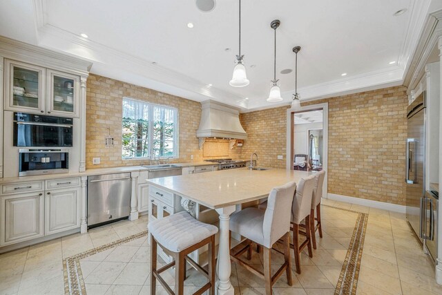 184-61 Radnor Rd, Jamaica Estates, NY 11432 - kitchen featuring stainless steel dishwasher, premium range hood, inlaid floor details, a sink, and a breakfast bar