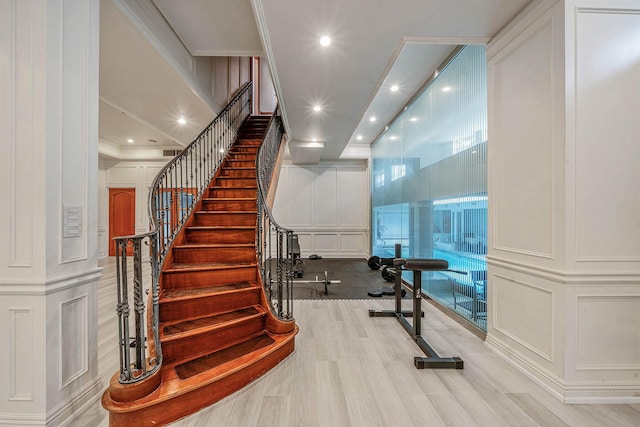 184-61 Radnor Rd, Jamaica Estates, NY 11432 - staircase featuring a decorative wall, recessed lighting, crown molding, and wood finished floors