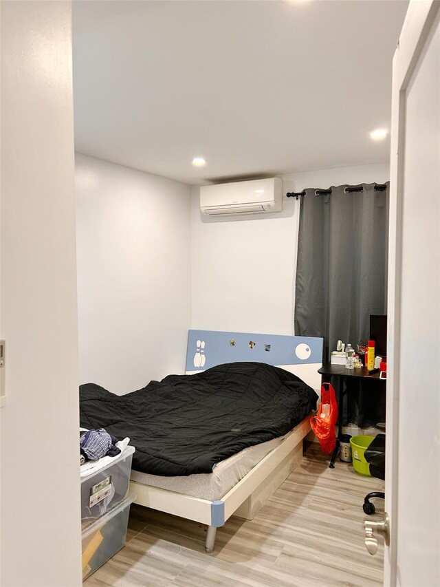 54-23 153rd St, Flushing, NY 11355 - bedroom with an AC wall unit, wood finished floors, and recessed lighting