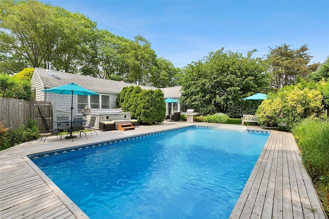 40 Maidstone Ave, East Hampton, NY 11937 - outdoor pool featuring a hot tub, a deck, and view of scattered trees