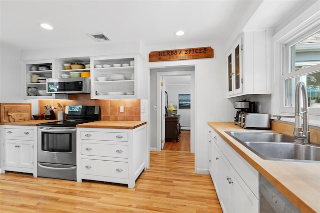 40 Maidstone Ave, East Hampton, NY 11937 - kitchen featuring appliances with stainless steel finishes, a sink, light wood-style flooring, white cabinets, and recessed lighting