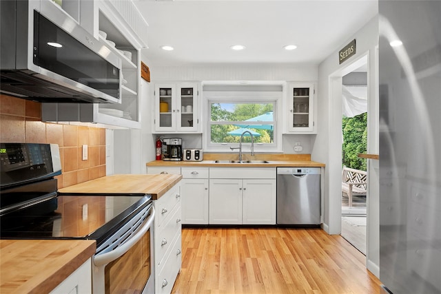 40 Maidstone Ave, East Hampton, NY 11937 - kitchen with butcher block countertops, stainless steel appliances, a sink, light wood-type flooring, and recessed lighting