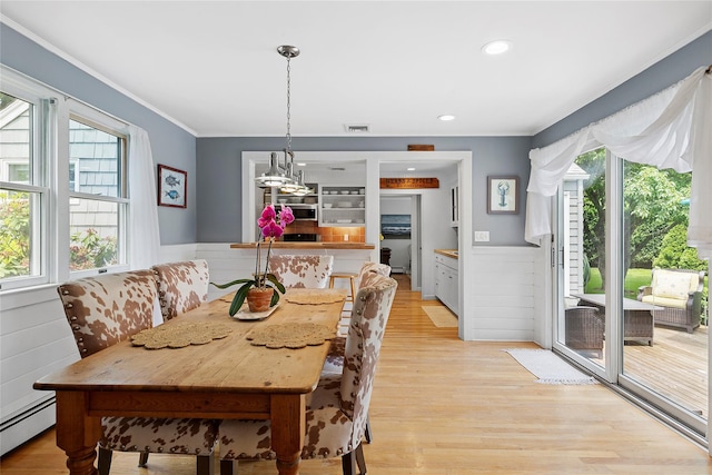 40 Maidstone Ave, East Hampton, NY 11937 - dining room with a baseboard radiator, a wainscoted wall, light wood finished floors, ornamental molding, and a chandelier