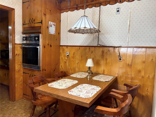 324 Westside Ave, Haverstraw, NY 10927 - dining room with wallpapered walls, a wainscoted wall, wooden walls, and brick patterned floors