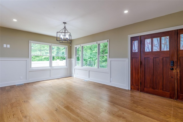 22 Commonwealth Ave, Massapequa, NY 11758 - foyer featuring a decorative wall, a chandelier, wainscoting, light wood-style floors, and recessed lighting