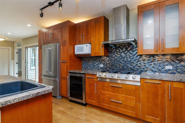 22 Commonwealth Ave, Massapequa, NY 11758 - kitchen with stainless steel appliances, wall chimney range hood, beverage cooler, light wood-type flooring, and brown cabinets