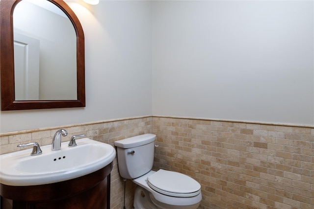22 Commonwealth Ave, Massapequa, NY 11758 - half bath featuring toilet, wainscoting, tile walls, and a sink