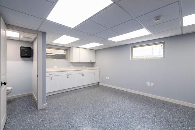 22 Commonwealth Ave, Massapequa, NY 11758 - basement featuring baseboards and a drop ceiling