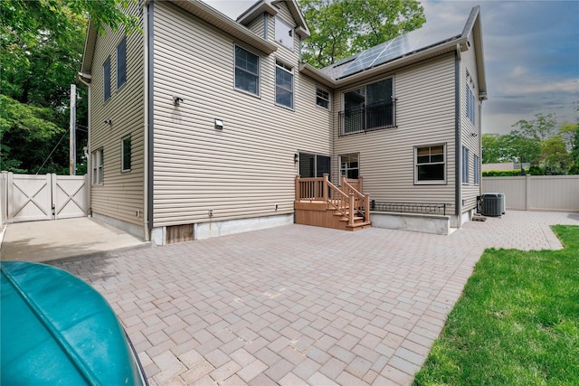 22 Commonwealth Ave, Massapequa, NY 11758 - rear view of property with solar panels, a gate, a patio area, a balcony, and a fenced backyard