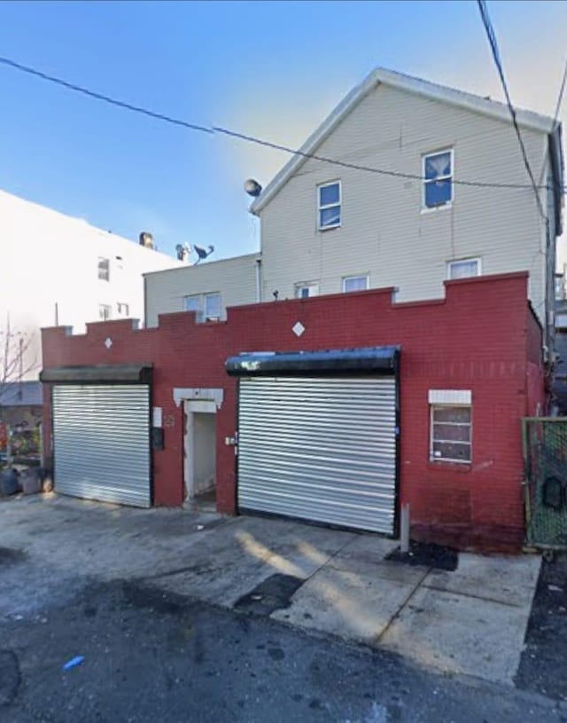 132 Oak St, Yonkers, NY 10701 - view of front of home featuring brick siding, driveway, and an attached garage