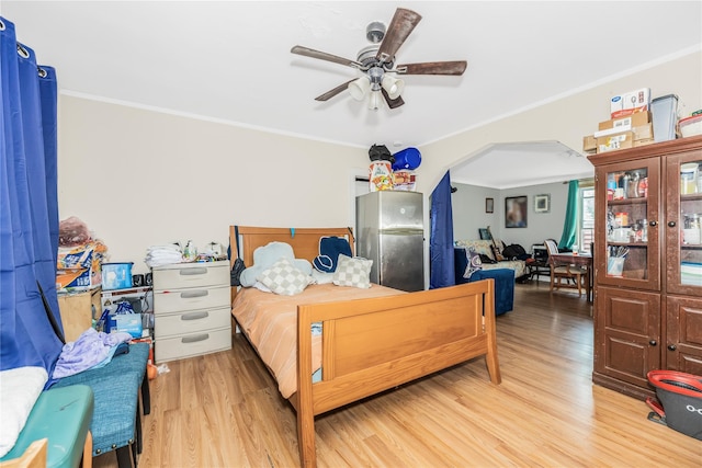 132 Oak St, Yonkers, NY 10701 - bedroom featuring arched walkways, freestanding refrigerator, light wood-style flooring, and crown molding