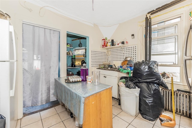 132 Oak St, Yonkers, NY 10701 - kitchen featuring freestanding refrigerator, open shelves, light tile patterned floors, and white cabinetry